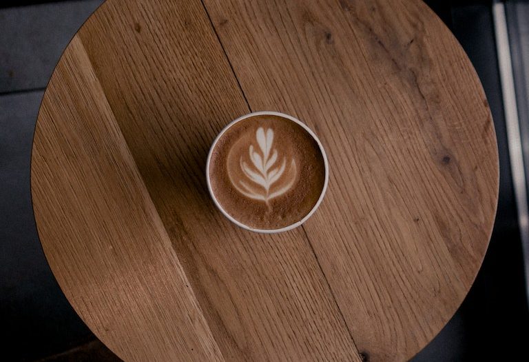 Latte art in cup of coffee on a Round Table